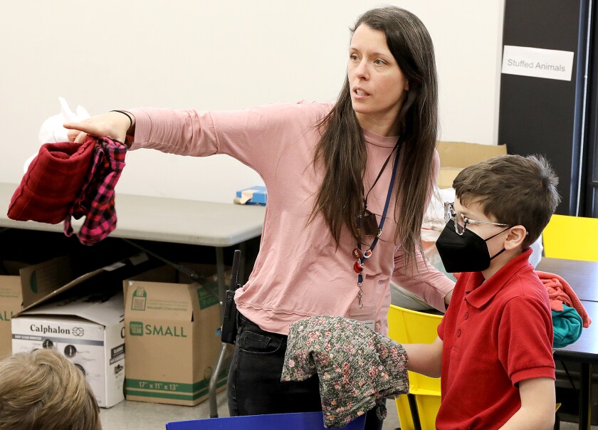 Amber Nielsen points out where she wants a shirt to go to fifth grader Frank Robbins at Cathedral School