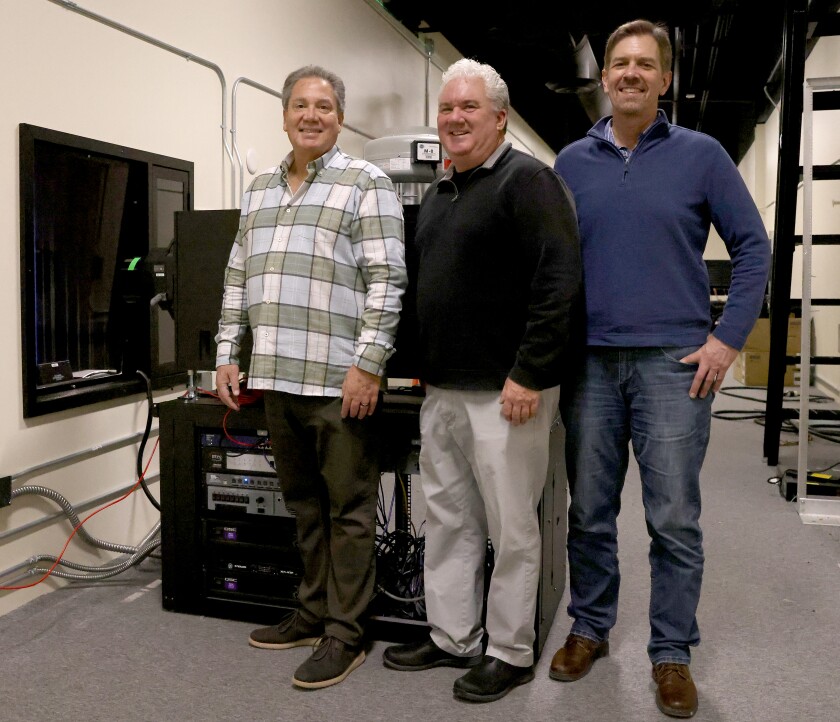 New Grand Theatre partner operators, from left, Kevin Donovan, Todd Frager and Dave Fetters pose in the projection room of the theater Friday.