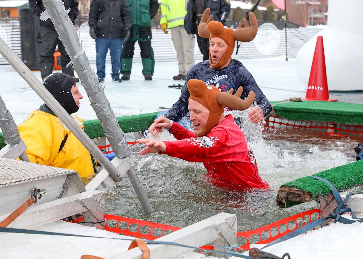 People jump into the water during the Polar Plunge event on Pelican Lake.