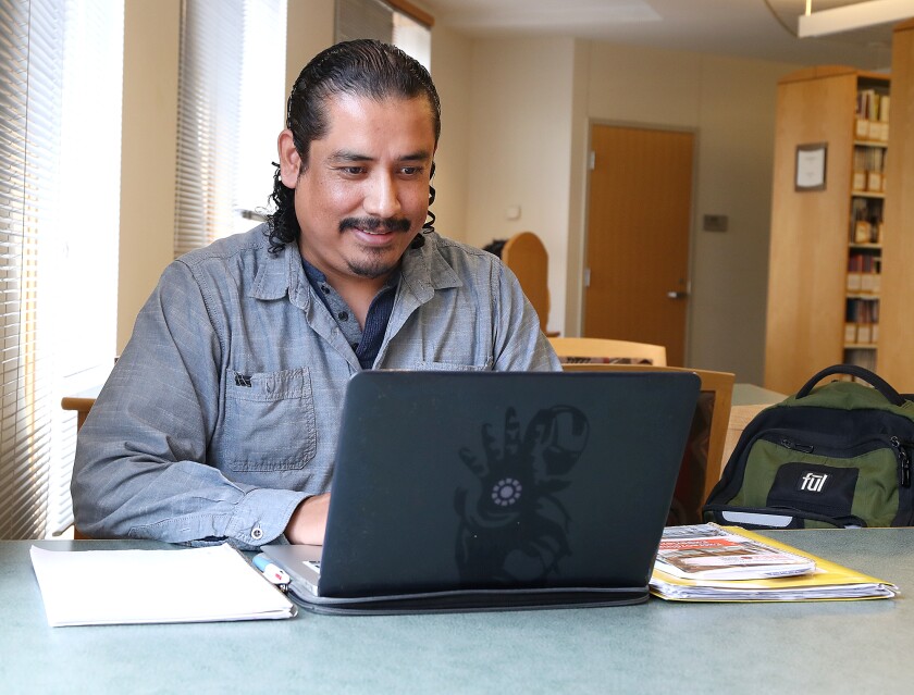Nahin Gatica Cruz looks at his laptop while studying in the library at Fond du Lac Tribal and Community College