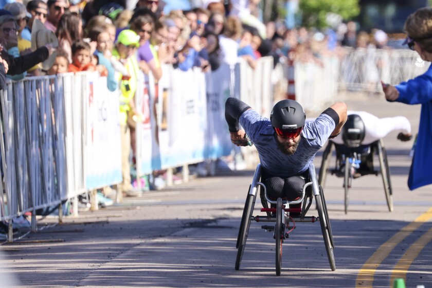 Athletes running and celebrating at the finish line area of Grandma's Marathon