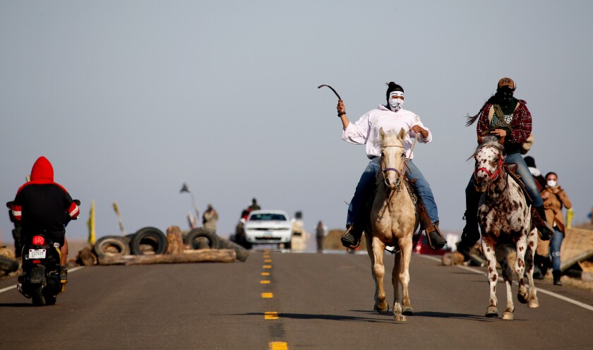 Horsemen spread the news of arriving law enforcement officers Oct. 27, 2016, at the Dakota Access Pipeline protest site on North Dakota Hwy. 1806 north of Cannon Ball. Michael Vosburg / Forum Photo Editor