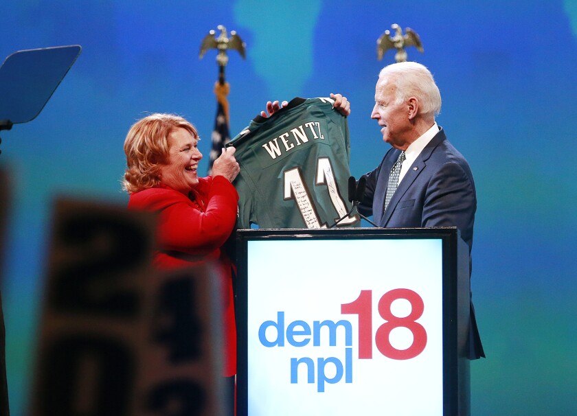 Joe Biden accepts an autographed Carson Wentz jersey from U.S. Sen. Heidi Heitkamp at the conclusion of Biden's speech at the North Dakota Democratic convention in Grand Forks Saturday. Photo by Eric Hylden/Grand Forks Herald