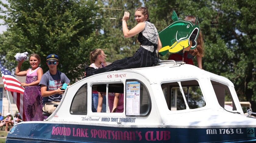Mermaids aboard the Round Lake Sportsmen's Club boat float wave to the crowd as they go through the Independence Day parade Monday afternoon, July 4, 2022.