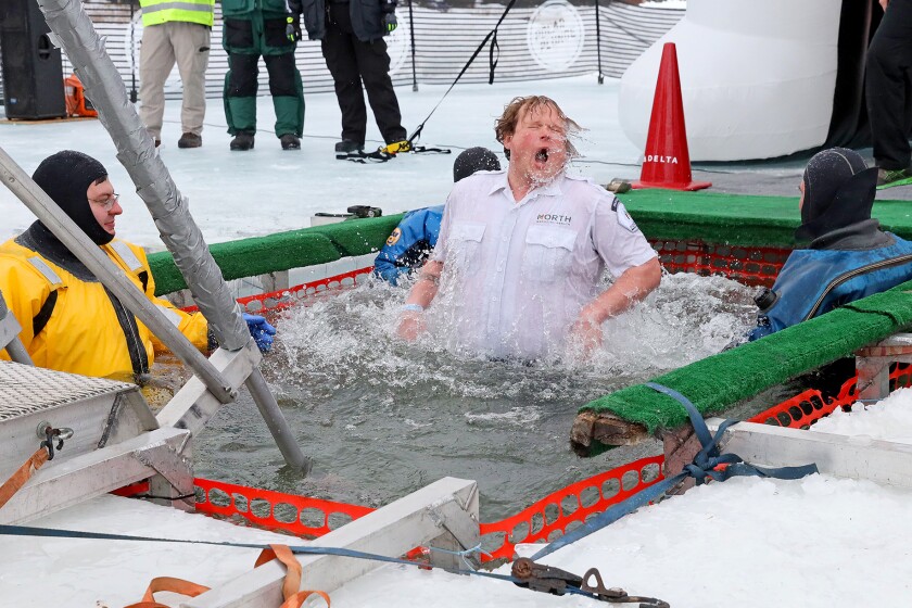 People jump into the water during the Polar Plunge event on Pelican Lake.