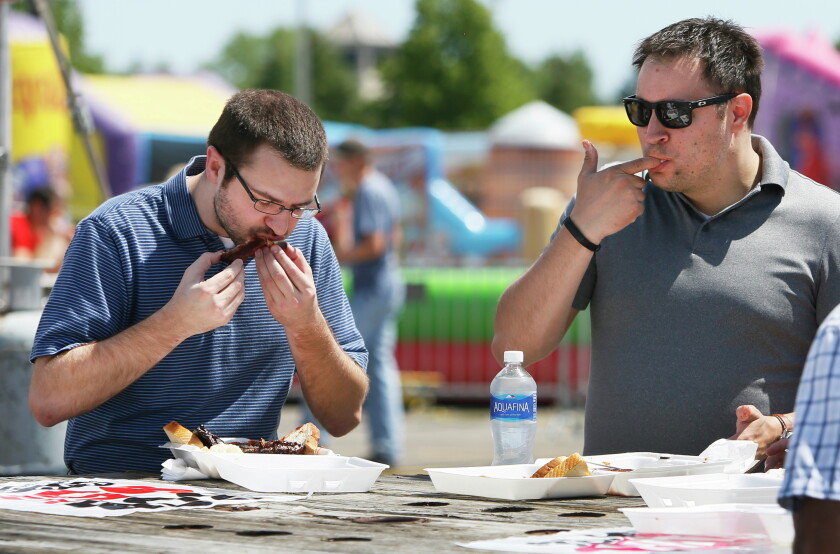 Kevin Howard, cozinheiro do Johnson's Hickory Smoked Bar-B-Que de Norfolk, VA, gerencia uma variedade de entradas de churrasco enquanto uma fila de clientes faz seus pedidos na quarta-feira, 8 de junho, durante o Happy Harry's Ribfest 2016 fora do Fargodome. O festival começou às 11h e continua até sábado até às 23h Matt Hellman / The Forum