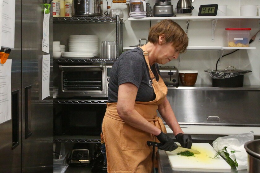 Andrea Baumgardner chops dill for a recipe on Thursday, Nov. 20, 2025, at Michelle's Table in Fargo.