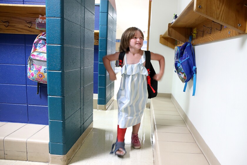 Paislee Rizzo smiles as she takes off her backpack