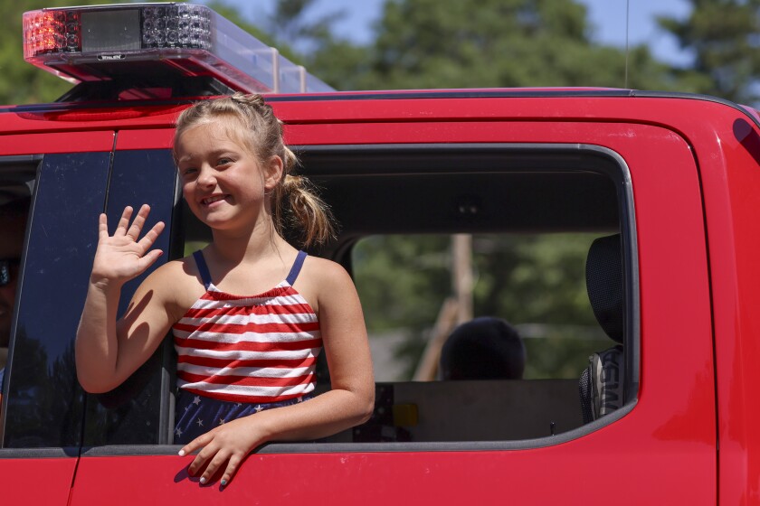People wearing red white and blue patriotic themed clothing participating in outdoor parade
