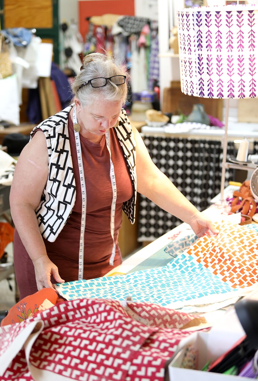 Kirsten Aune looks over fabric in her shop Kirsten Aune Textiles