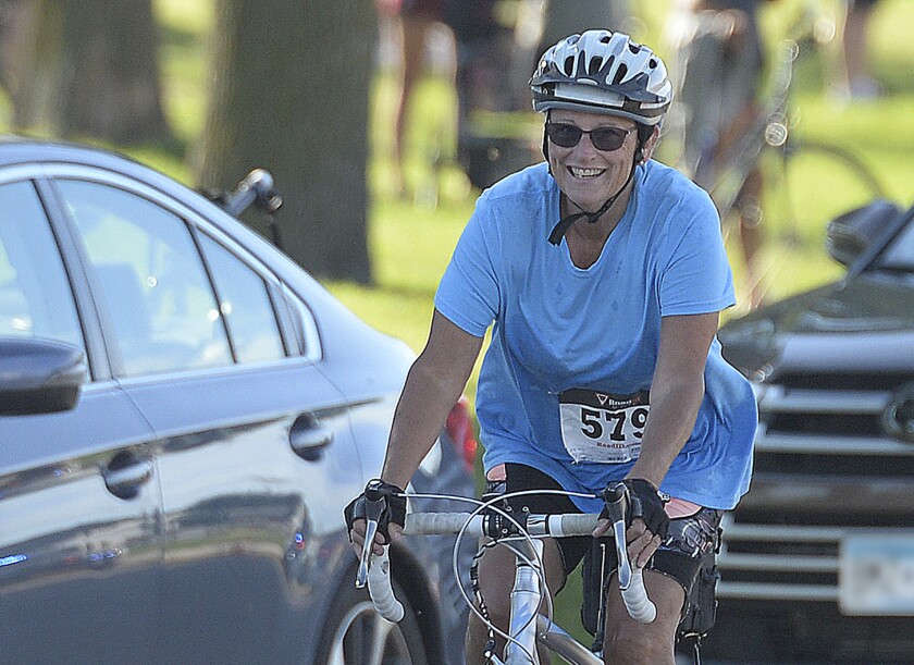 Spicer's Sharon Oleson is all smiles as she begins her 14-mile bike ride during the Green Lake Triathlon on Sunday, Aug. 14, 2022 at Spicer.