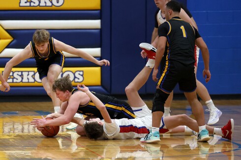 Players fight for loose ball on the ground.