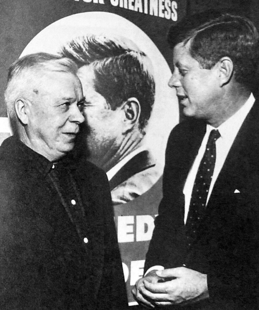 A historical photo of two men having a conversation.