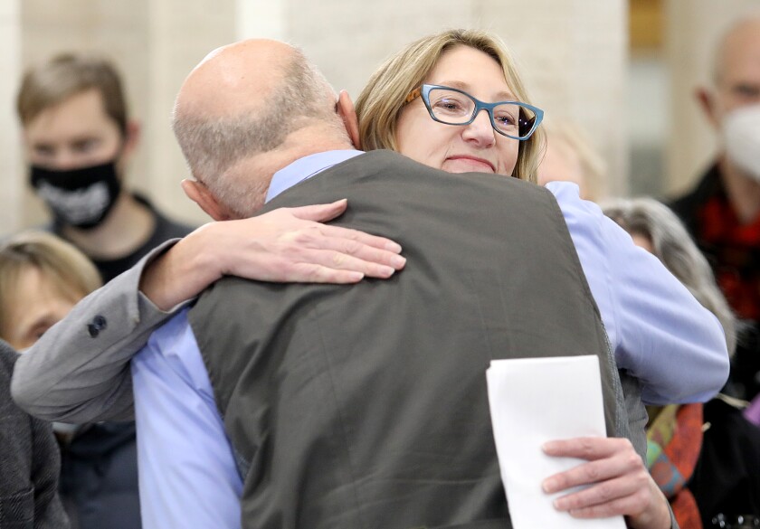 Jen Schultz gets a hug from Duluth City Councilor Gary Anderson