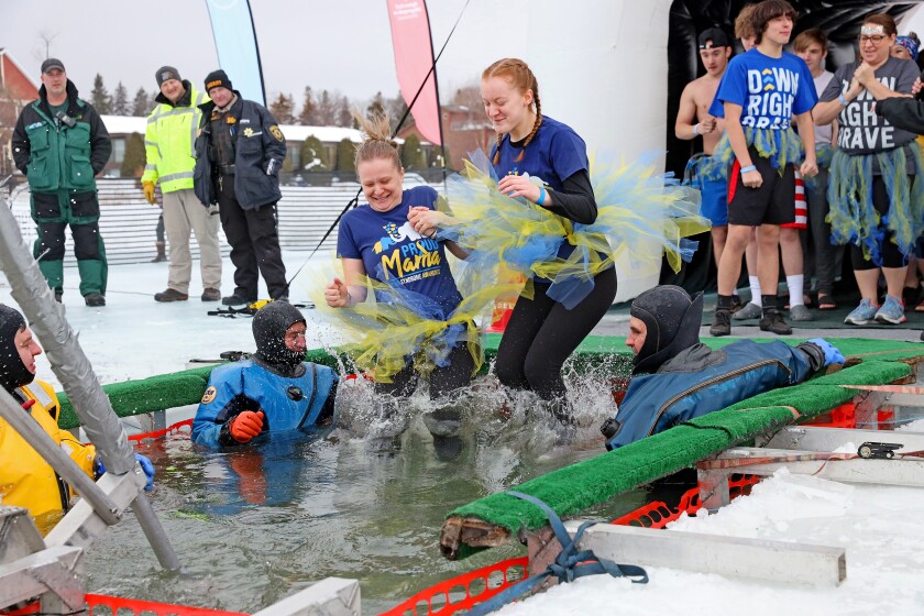People jump into the water during the Polar Plunge event on Pelican Lake.