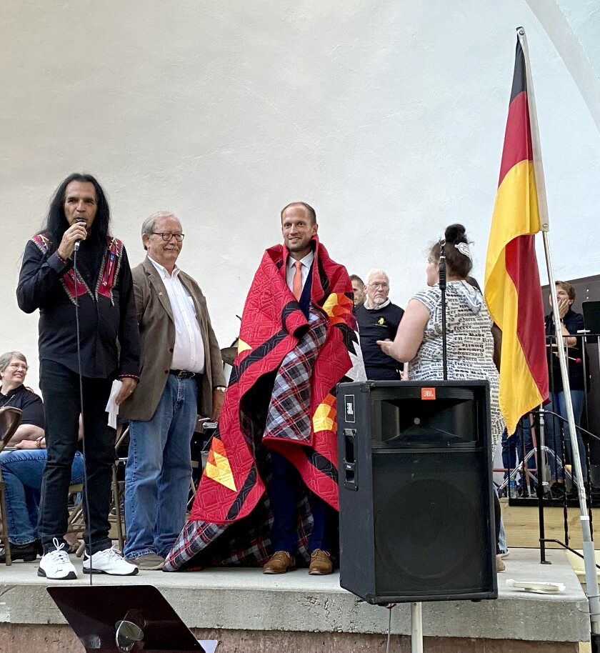 Dr. Christoph Grimmer, oberburgermeister of Crailsheim, Germany, is draped in a Lakota star quilt during the 75th anniversary celebration of the sister city partnership Wednesday evening, June 8, 2022, in Worthington's Chautauqua Park.