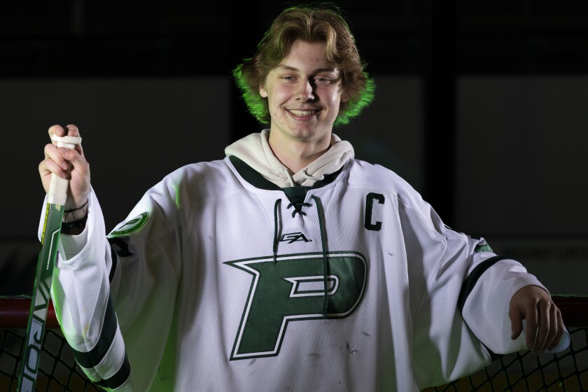 High school hockey player poses with his stick