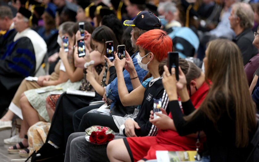 People hold up their cell phones