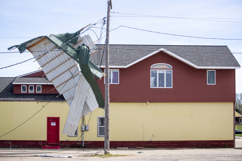 Metal roofing hangs on power lines in downtown Kerkhoven the morning of Friday, May 13, 2022.