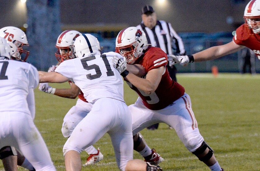 Willmar junior Dylan Goblirsch, middle, blocks Delano's Heston Larive, 51, during a North Central White District game on Friday, Sept. 30, 2022 at Hodapp Field.