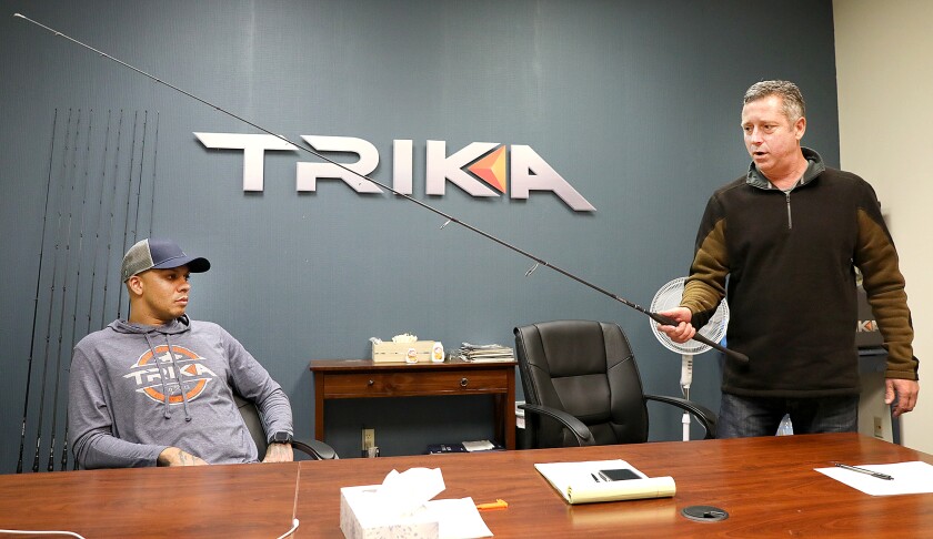Michael Wienkauf, right, the Executive Vice President at Trika, shows one of the company’s rods while Tyson Owens looks on