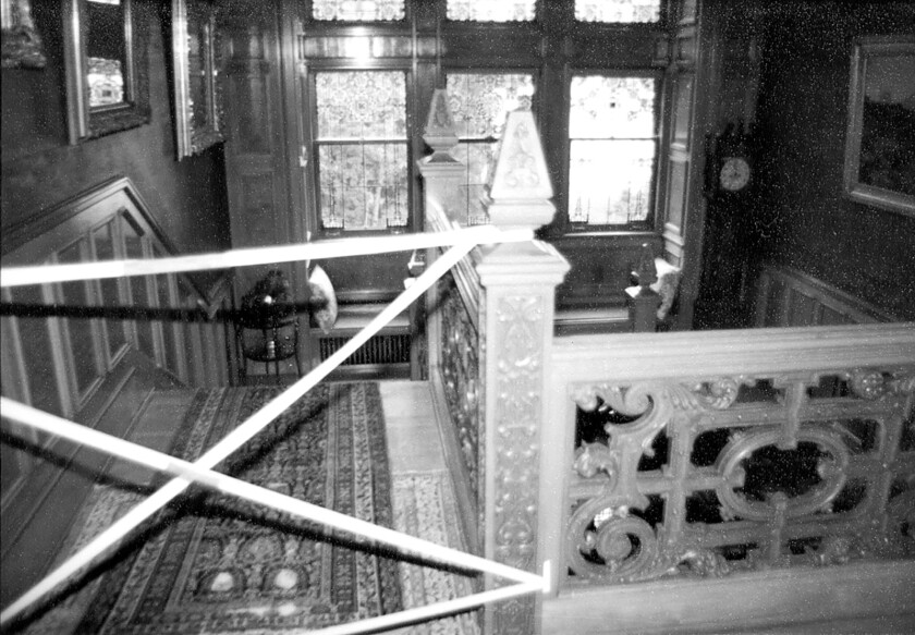 The stairwell where Velma Pietila was killed at Glensheen on June 27, 1977 is taped off as police investigate and process the crime scene. The photo was taken in front of a table that held the brass candlestick used to bludgeon Pietila to death. (Image courtesy of Zenith City Press)