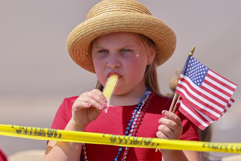 People wearing red white and blue patriotic themed clothing participating in outdoor parade