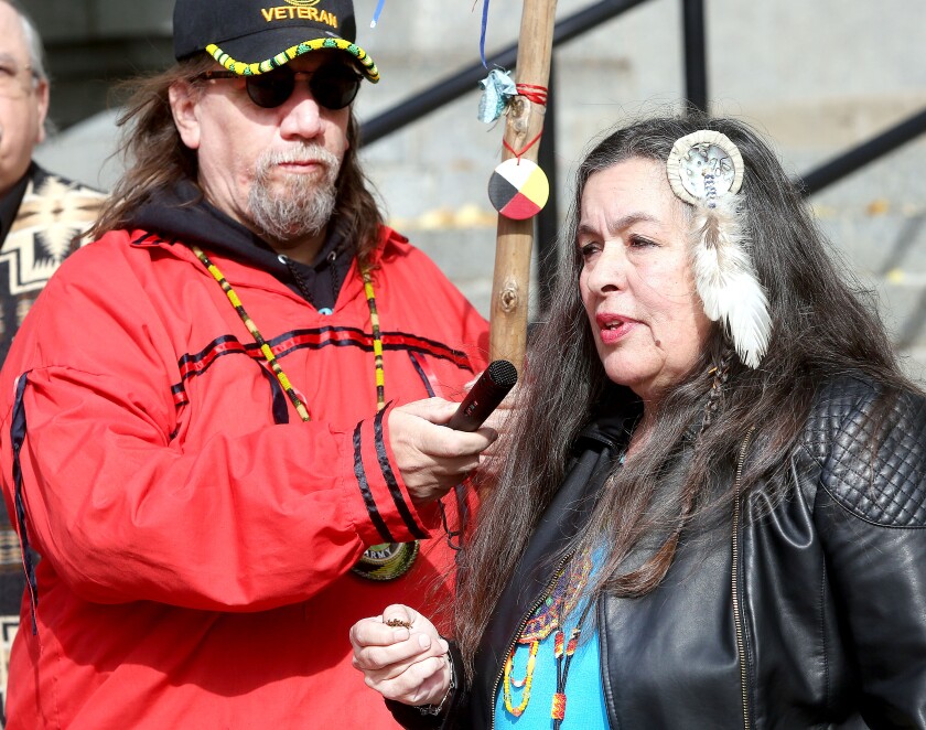 Shawn Carr holds the microphone as Babette Sandman, chair of the Duluth Indigenous Commission, gives a blessing during the Indigenous Peoples Day commemoration at City Hall on Monday. Bob King / rking@duluthnews.com