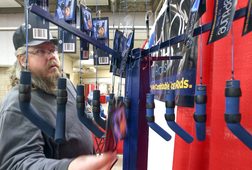 Man examines rack of fishing rods