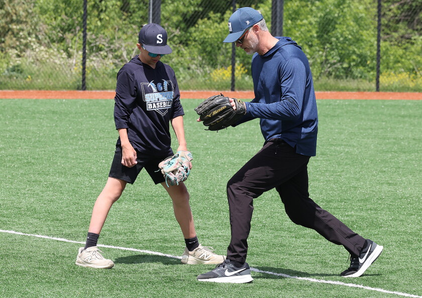 Pitcher helps kid with drill.