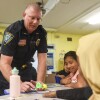 Willmar Police Officer James Venenga, who serves as a school resource officer, shows fifth-grade students Dalila Mus Gomez, center, and Deqa Shukre how a toy works during a class Wednesday at Kennedy Elementary School in Willmar.
