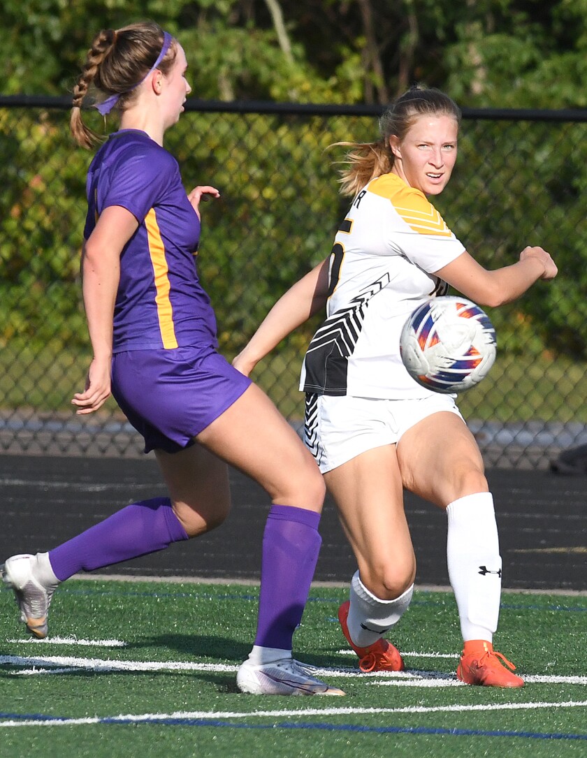 UW-Superior’s Allison Alessi (15) passes the ball up field in front of Northwestern’s Elle Bush (7)