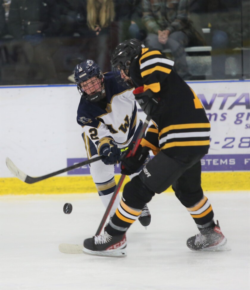 Hermantown's Jack Olson, 12, competes for the puck with Warroad's Carson Pilgrim.