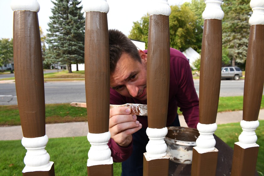 Taking advantage of a break from rain showers Wednesday, Sept. 26, Keith Gadacz painted the spindles on the railing at his north Brainerd home. Steve Kohls / Brainerd Dispatch