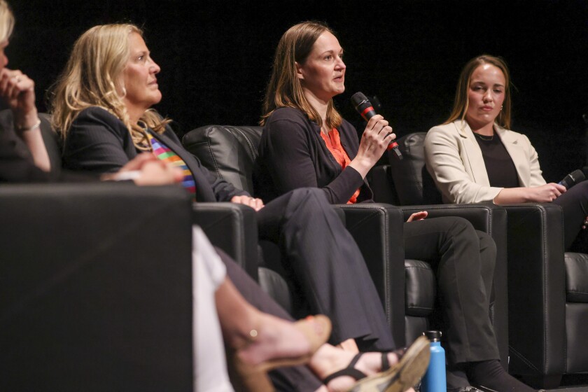 Women participating in live panel on theatre stage