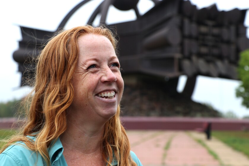 Woman talks in front of statue