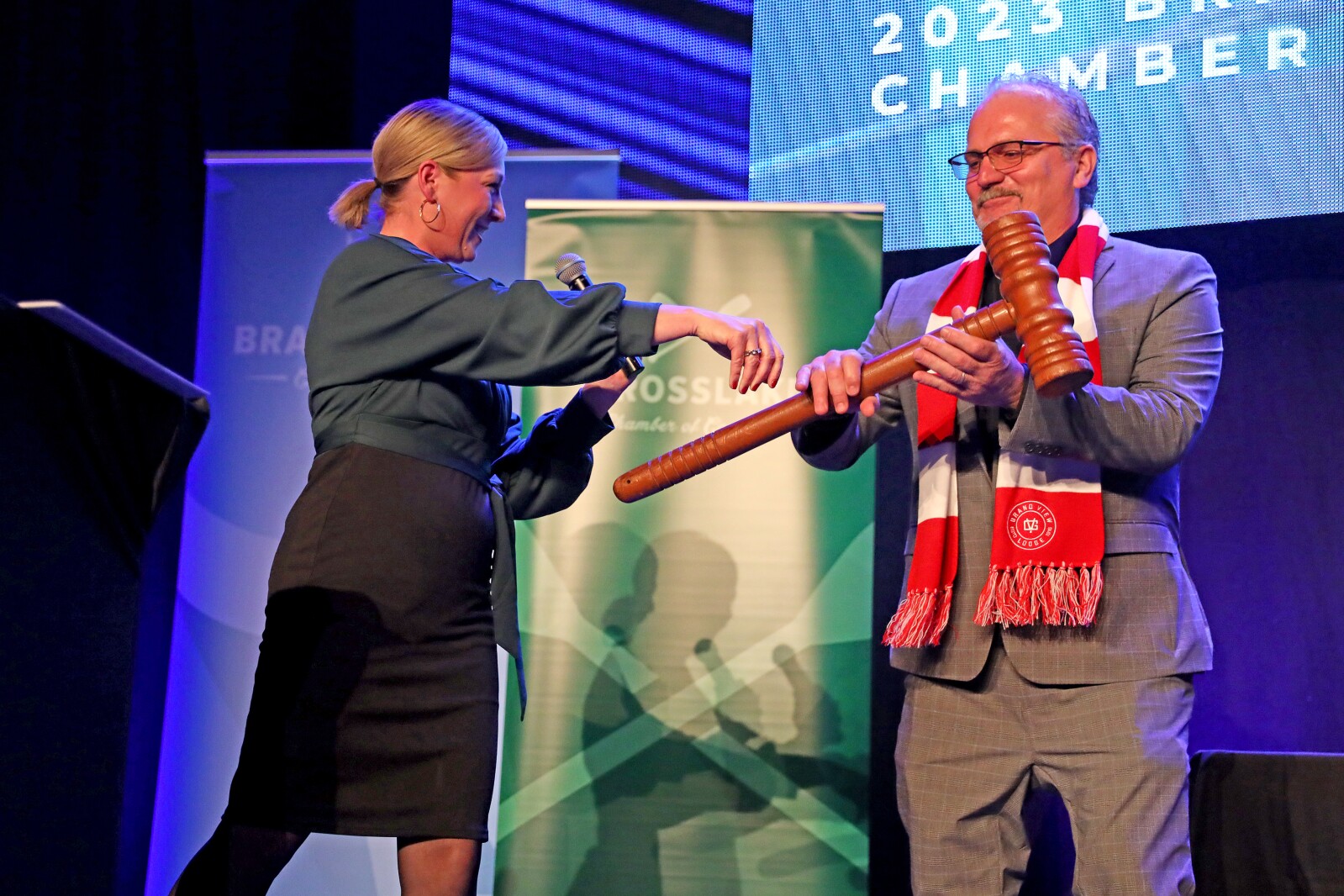 Jill Casper, 2022 Brainerd Lakes Chamber Board Chair, hands "Paul Bunyan's Gavel" to next year's BLC Board Chair Frank Soukup during the ninth-annual Brainerd Lakes Chamber of Commerce Celebration of Excellence award dinner Nov. 17, 2022, at Cragun's Resort on Gull Lake near Brainerd.
