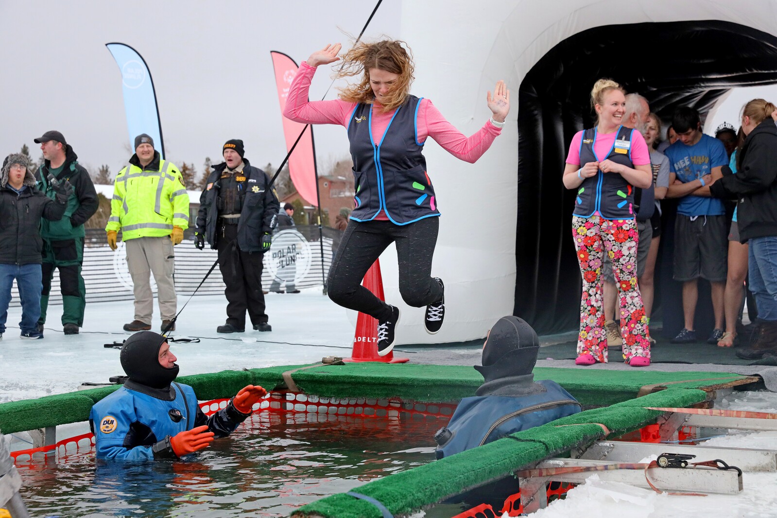 People jump into the water during the Polar Plunge event on Pelican Lake.