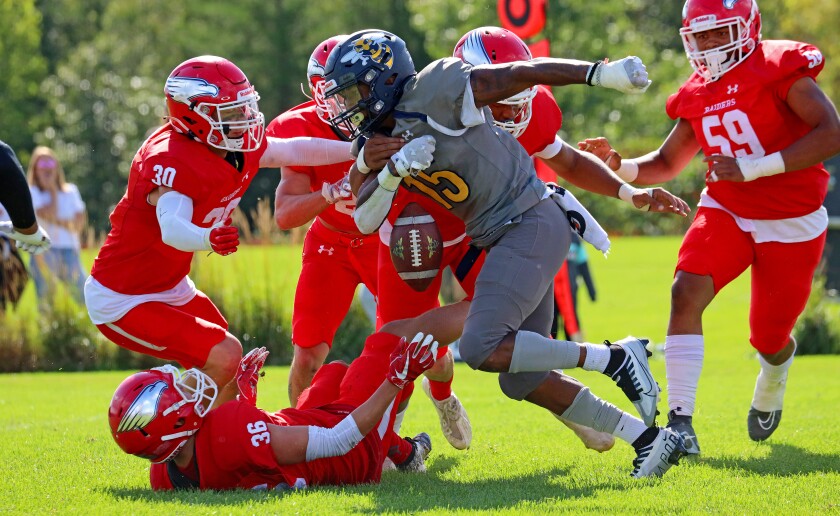 Rochester fumbles the ball amidst a host of Raider defenders.
