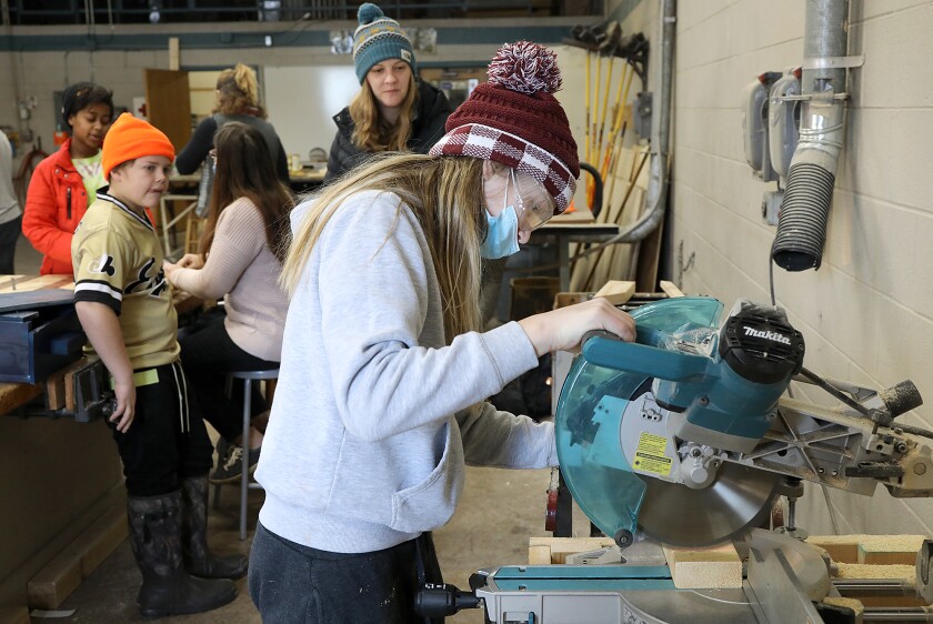 Sixth-grader Claire Beerntsen cuts a piece of wood