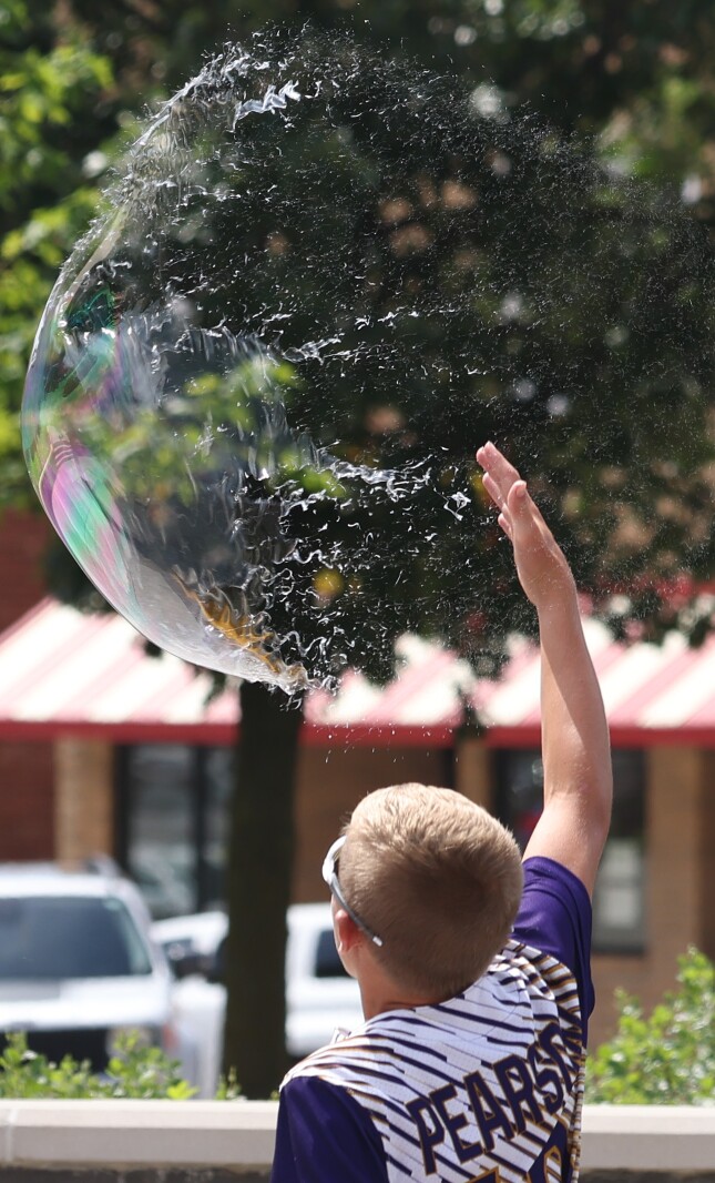 A bubble bursts with the tap of a finger at the International Festival Saturday, July 9, 2022.