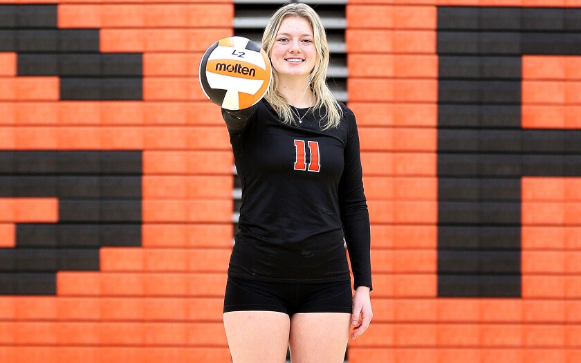 Grand Rapids junior Braya LaPlant extends her right arm while holding a volleyball