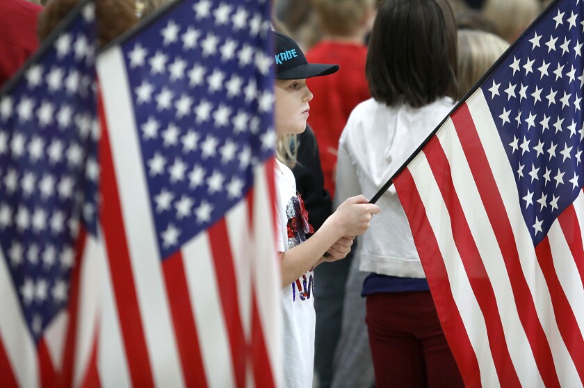 Third grader Kade Lawson, 8, holds his flag steady during a Veteran’s Day ceremony at Great Lakes Elementary School