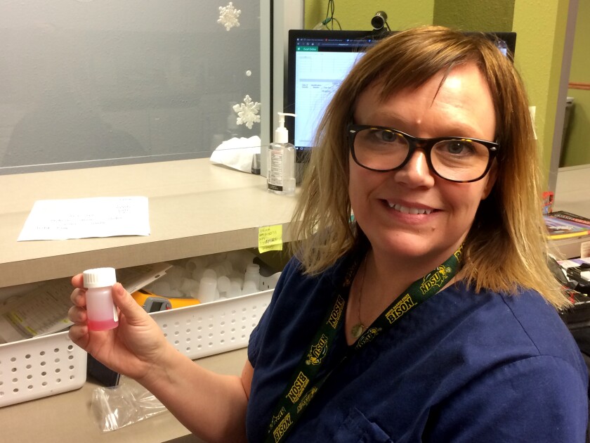 A nurse holds a dose of methadone, a drug that suppresses withdrawal symptoms for heroin and other opioids, helping addicts to go clean. Patrick Springer / Forum News Service