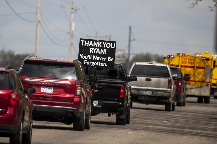 Signs supporting the late Ryan Leif Erickson are seen in his procession to Evergreen Cemetery in Blomkest following his funeral service at Refuge Church in Willmar on Friday, May 20, 2022.