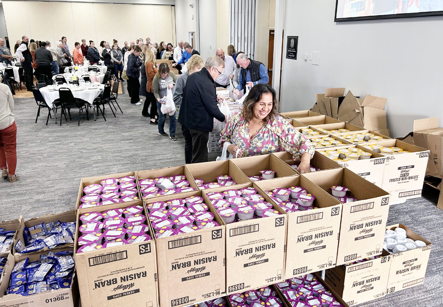 United Way luncheon attendees pack food bags for Backpack Attack ...