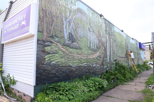 Artist works on mural.