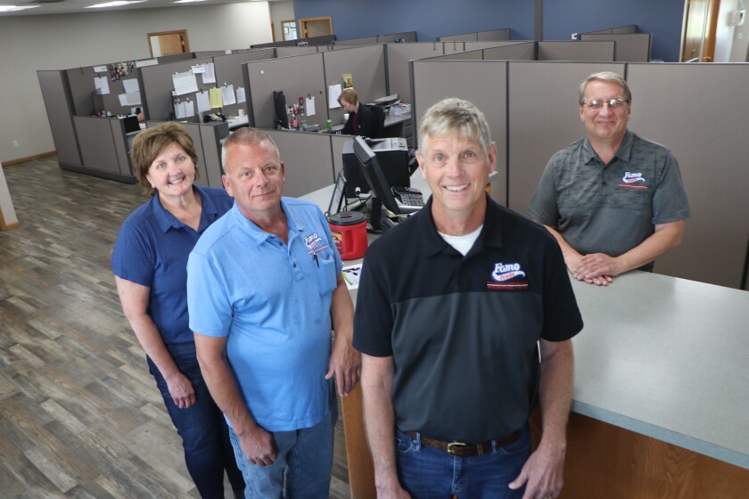 A feed manufacturing company owner (right-center) is flanked by some of his top executives.