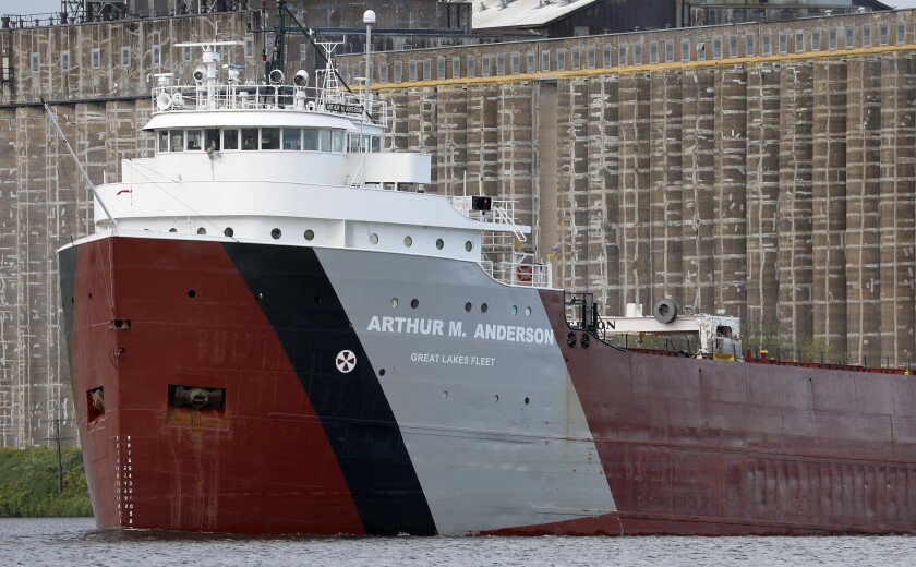 Great Lakes Freighter, se jménem Arthur M. Anderson namalovaný na boku, na klidné vodě poblíž přepravního terminálu.