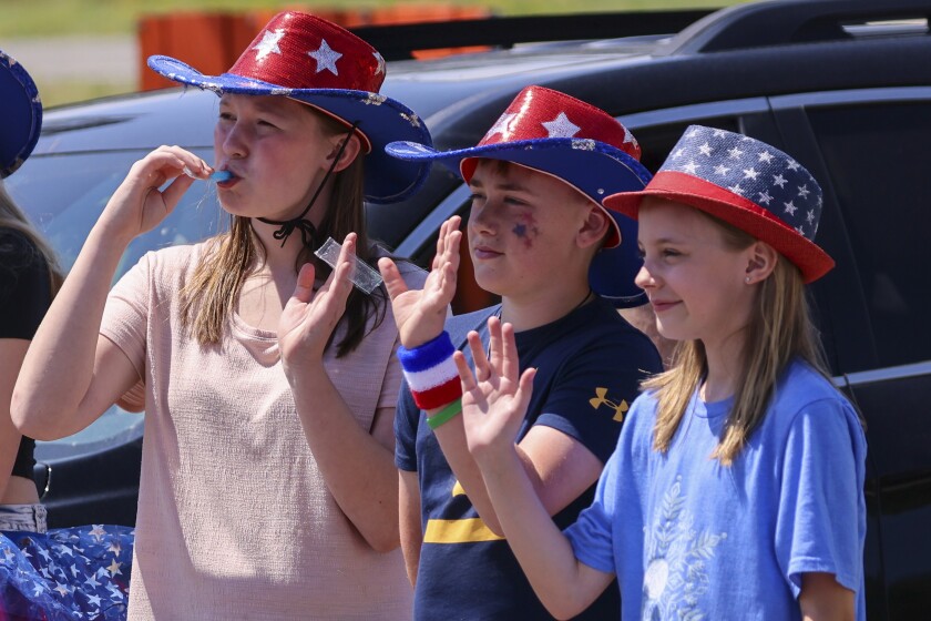 People wearing red white and blue patriotic themed clothing participating in outdoor parade